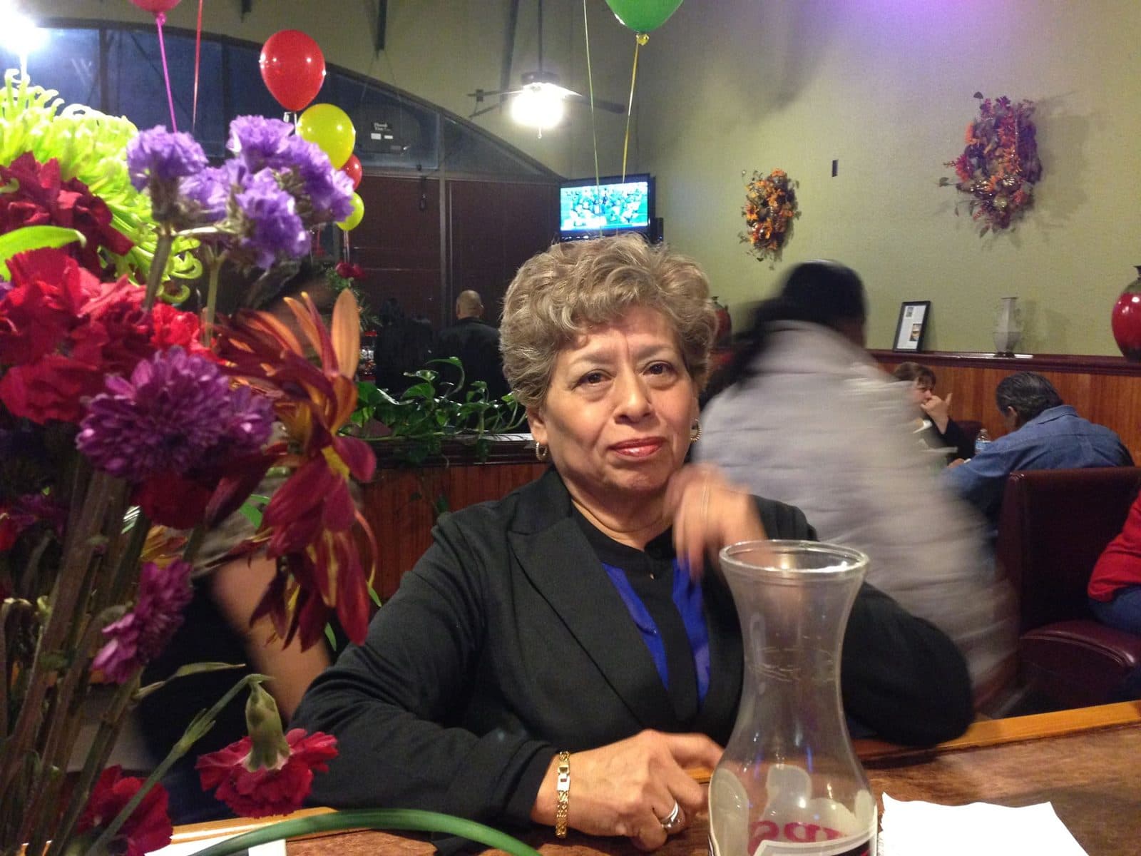 Mariana at a table in the restaurant, with flowers